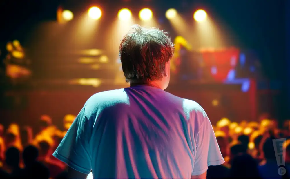 a photograph depicting the view from behind kyle hollingsworth performing on stage in front of an audience